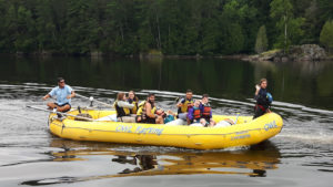 Sports Camp - A group of campers in a large white water raft